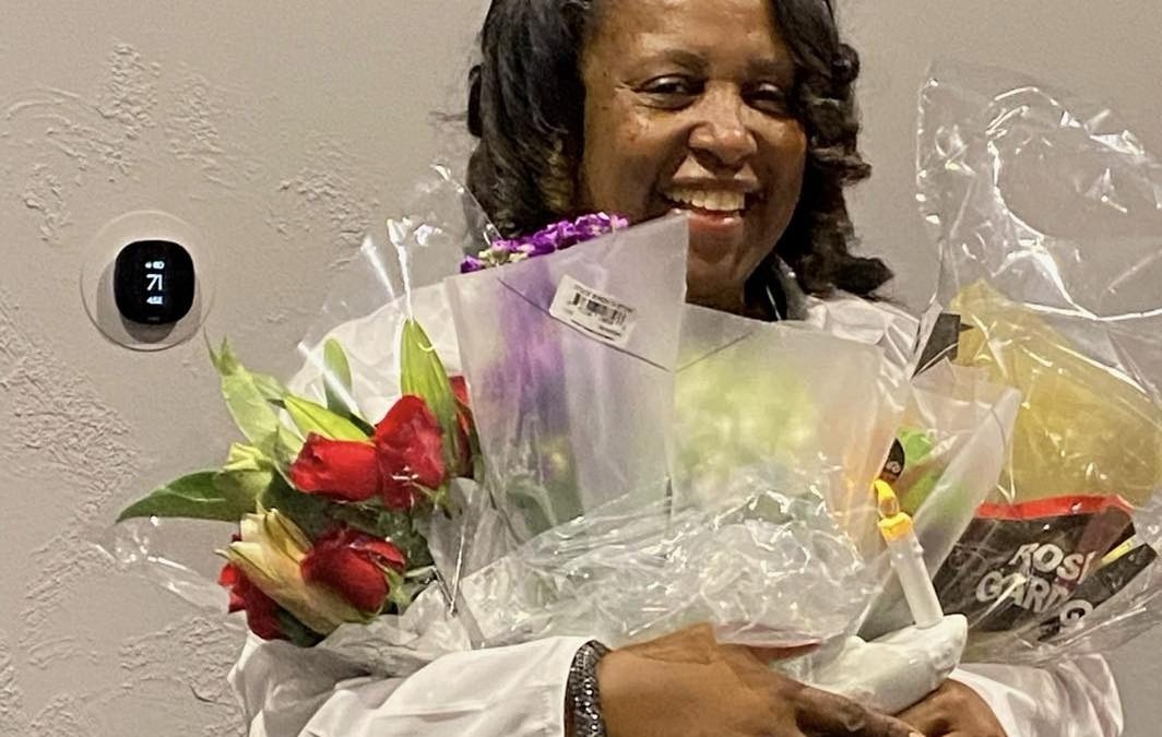 Smiling woman holder bunches of flowers. Photo introduces a story about success with The Workforce Connection helping Kim graduate from Rasmussen University.