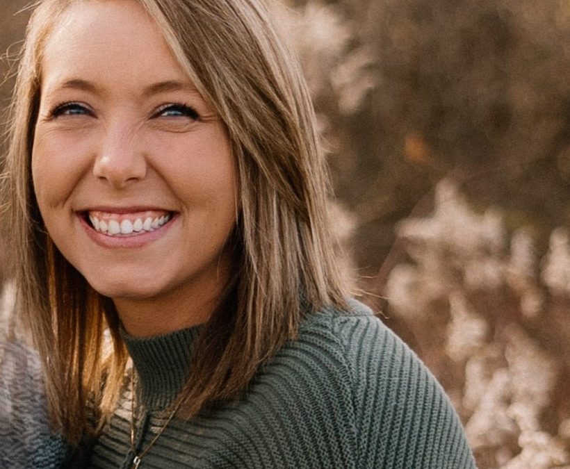 Photo introduces our newest staff member Emily. Smiling woman with medium blonde hair and a gray sweater.