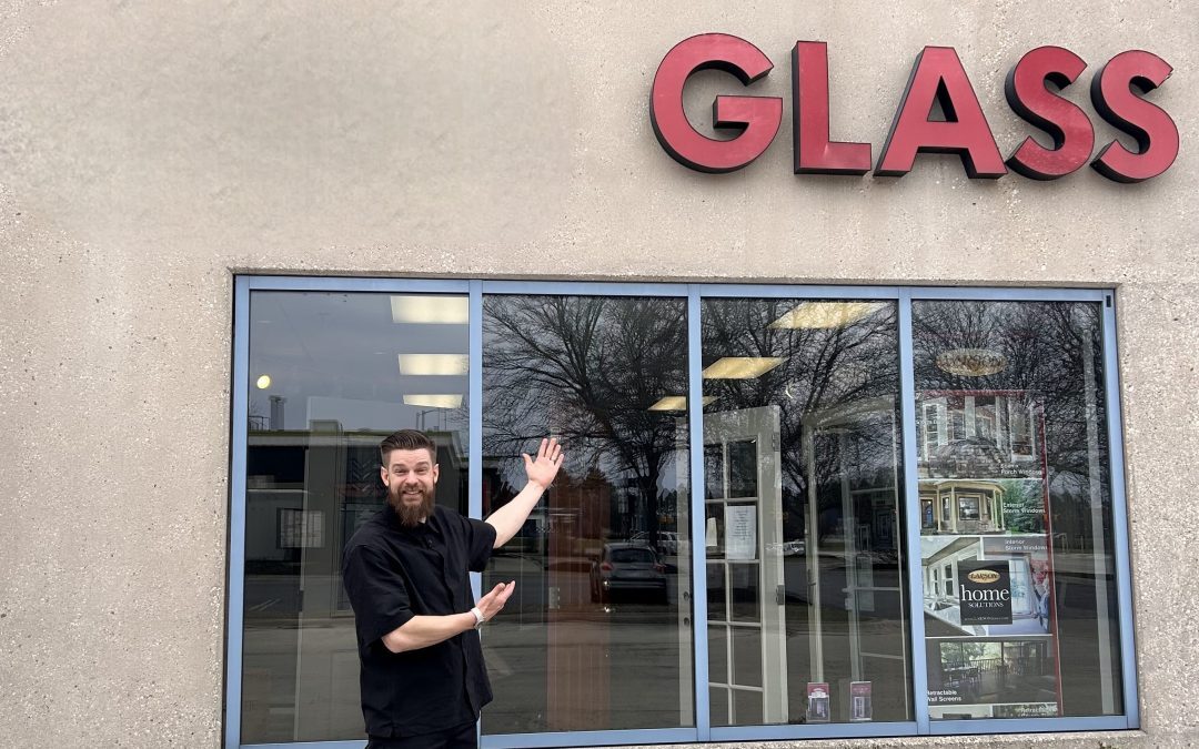 Photo of a man in black shirt and pants standing in front of the Rockford Glass store